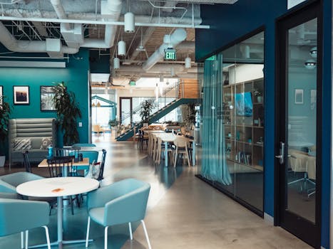 Open and collaborative modern office space with stylish furniture and natural lighting.